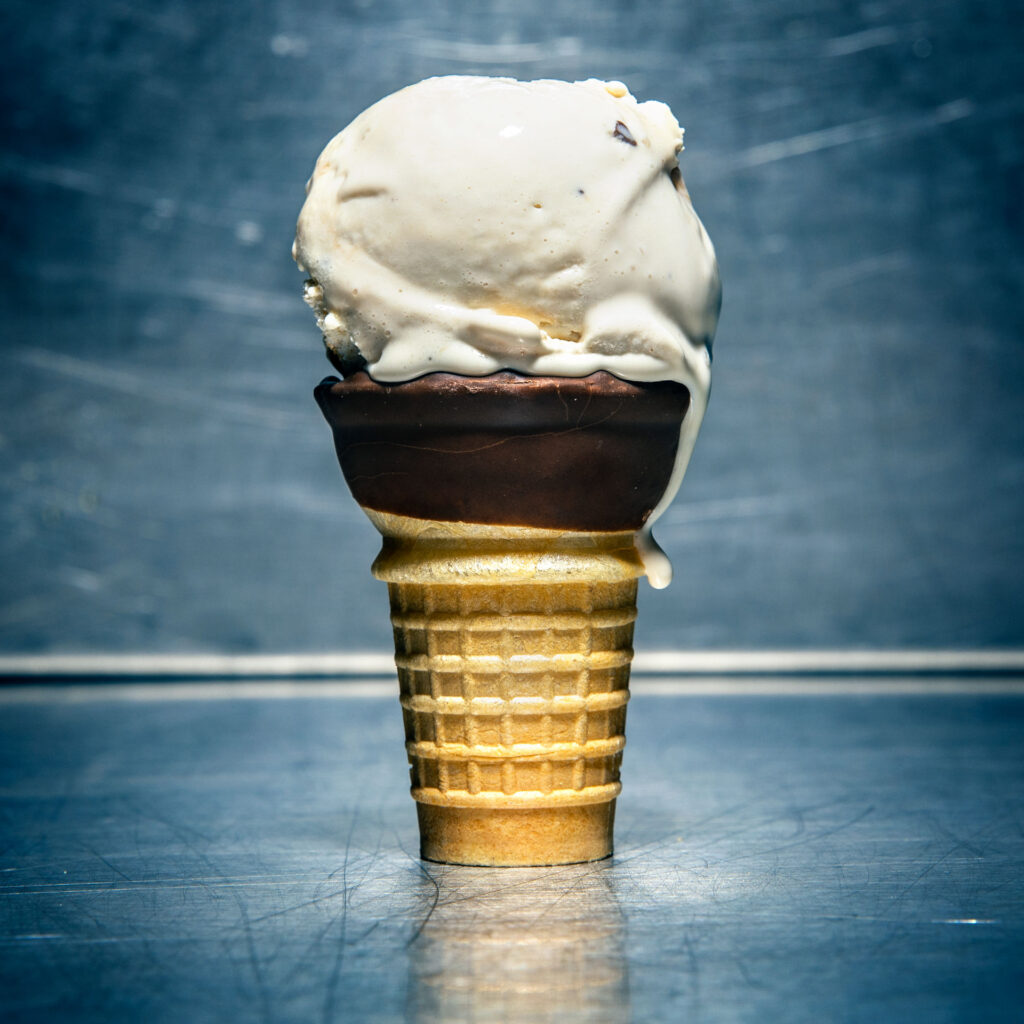 An ice cream cone containing a scoop of caramel ice cream.