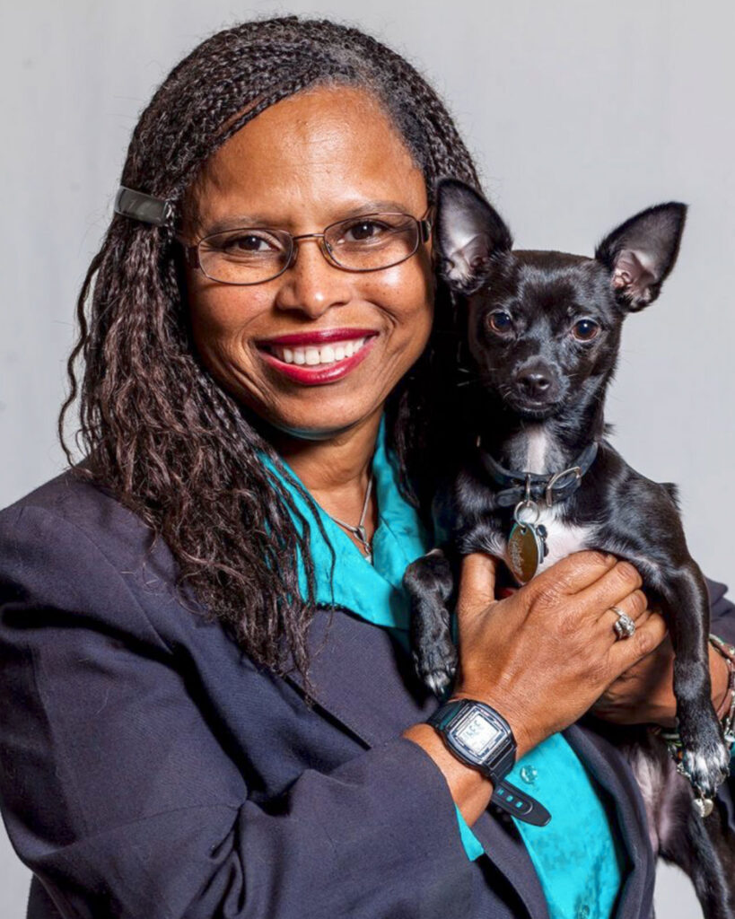 Dr. Lila Miller holding a small black-and-white dog.