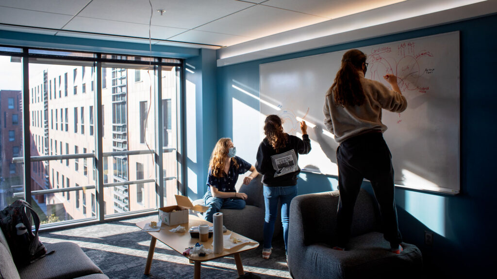students study and write on a whiteboard in Toni Morrison Hall