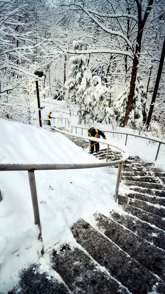 Cornell grounds staff shovel a stairway on campus