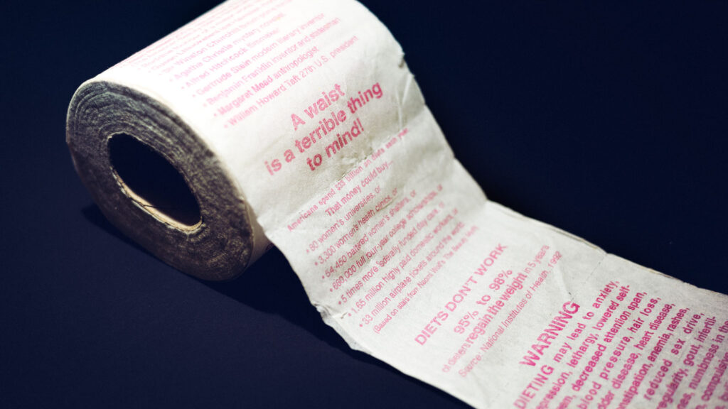 A roll of toilet tissue with body-positive messages printed in pink