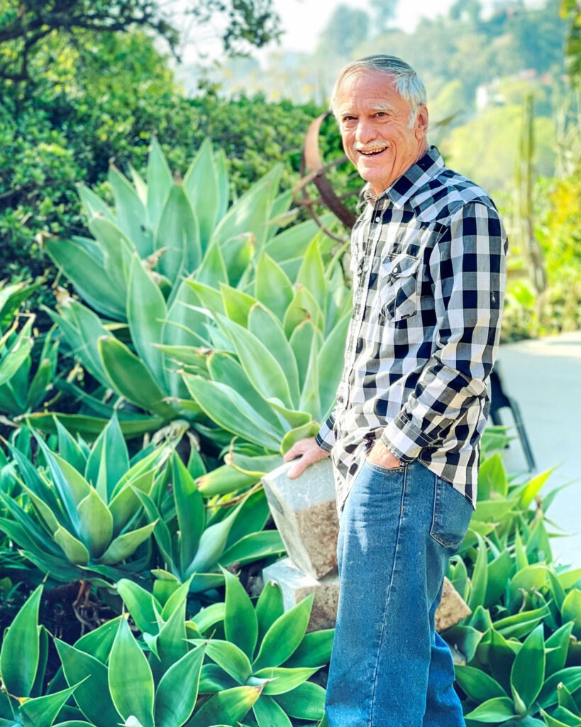 A photo of Park Nobel standing in his backyard cactus garden