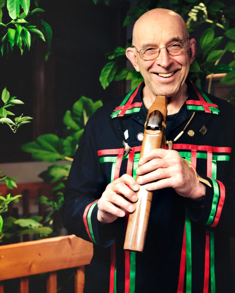 A photo of author Joseph Bruchac holding a wooden flute