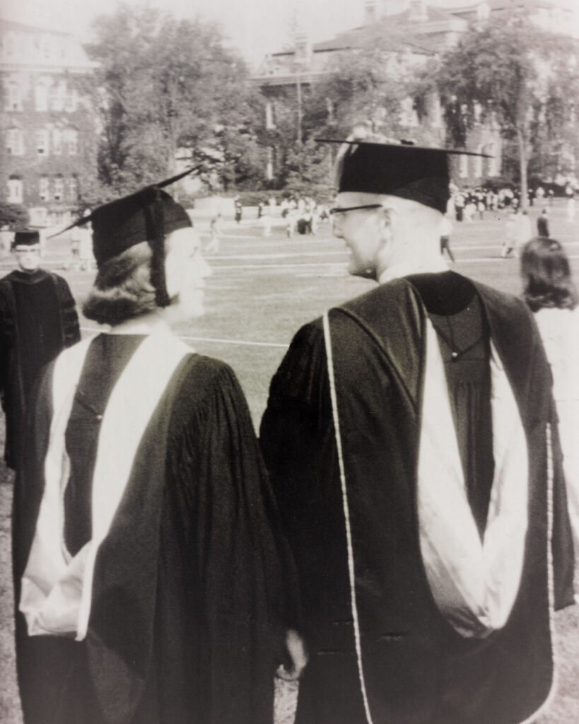 A man and a woman in graduation garb in B&W