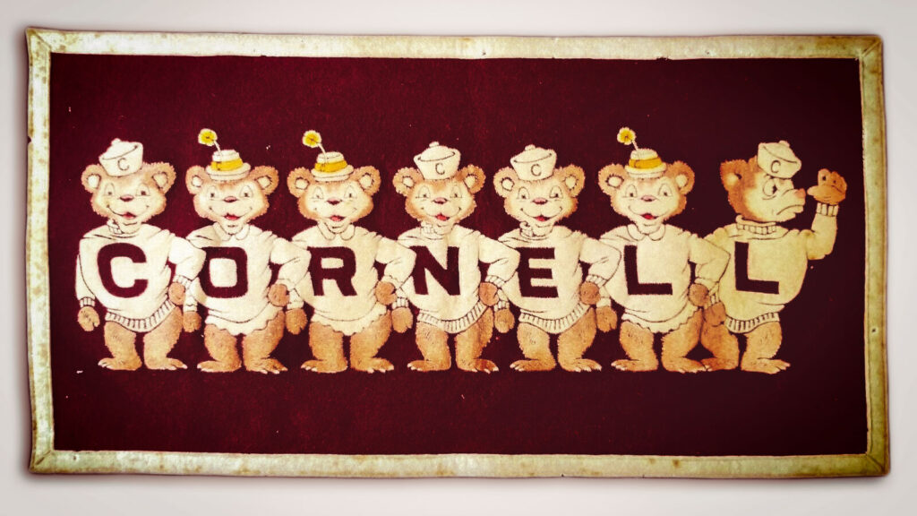 Seven lively Big Red bears spell out "Cornell" on this 1950s-era banner