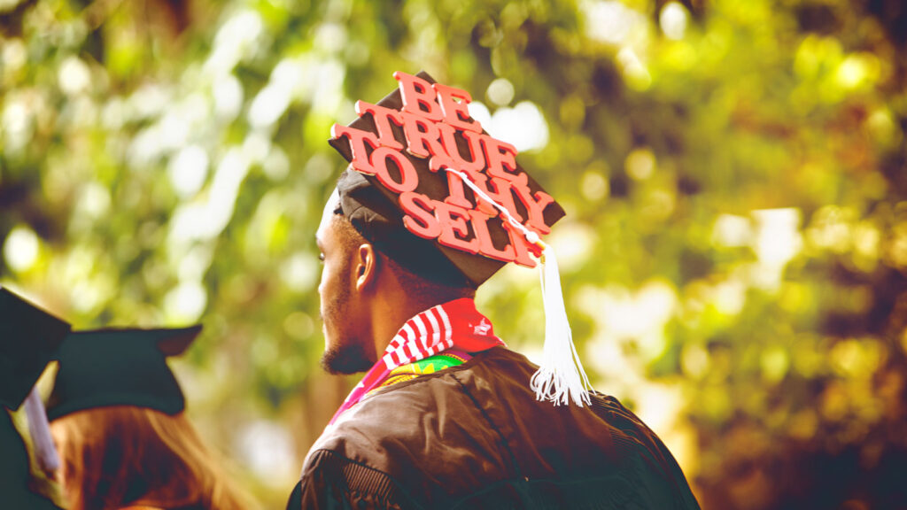 a decorated mortarboard on the head of a graduate at Commencement