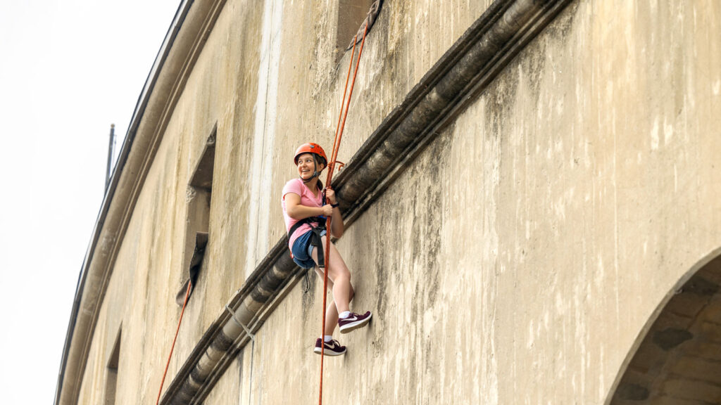 A Reunion attendee enjoys Cornell Outdoor Education’s rappelling activity on the side of Schoellkopf Stadium
