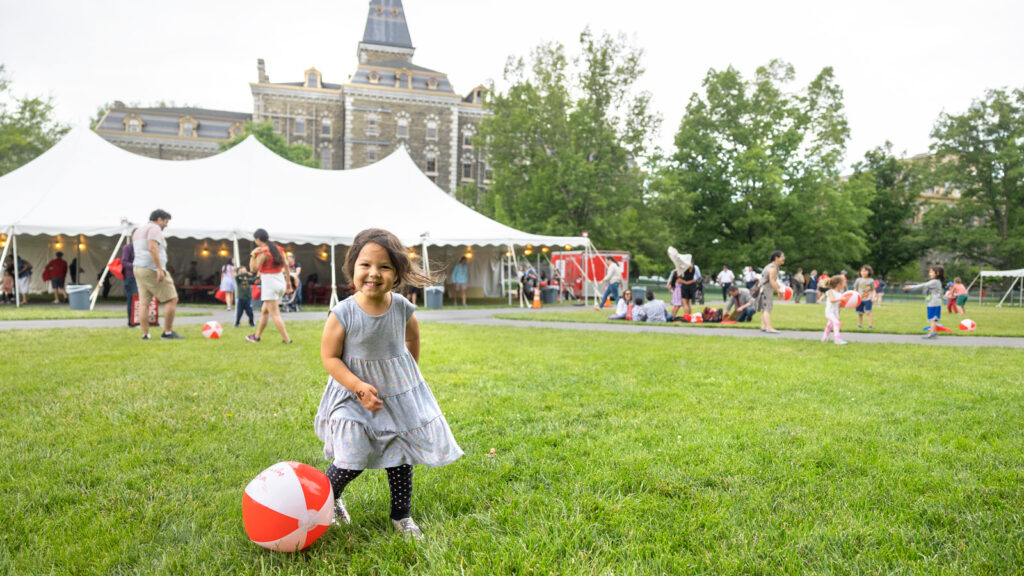 A child enjoys the Fun in the Sun festival on the Arts Quad during Reunion Weekend