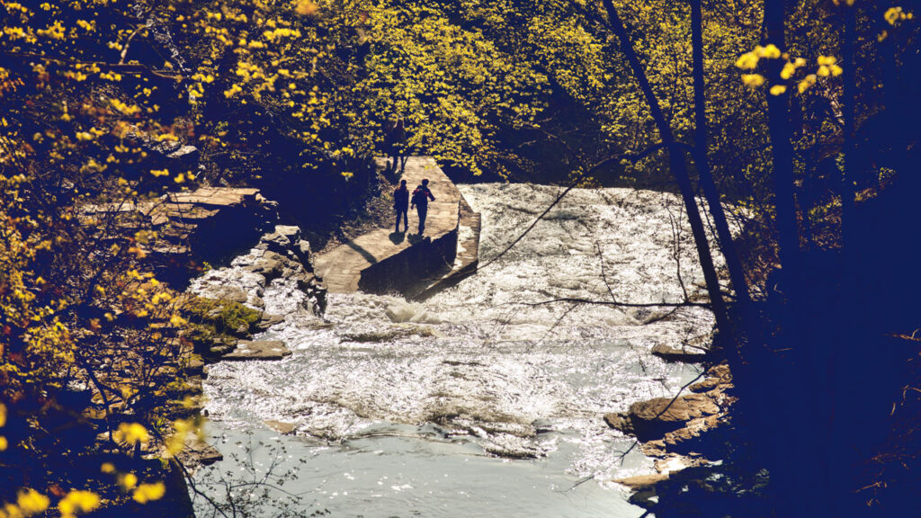 Two people walk along the Cascadilla Gorge Trail near campus