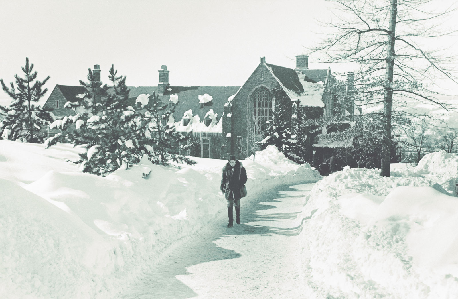 A woman in a winter coat in the snow near Willard Straight Hall