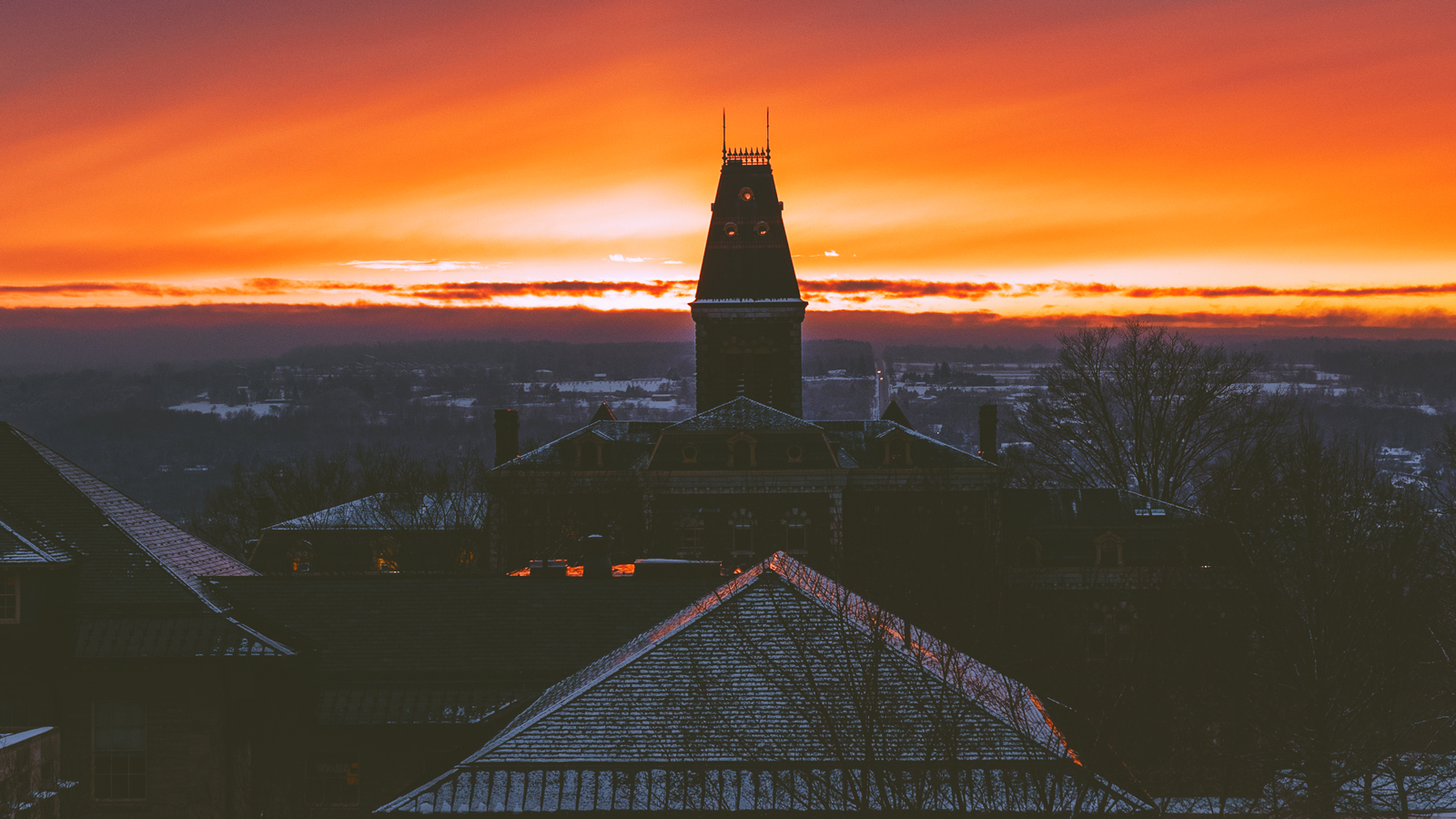 The sun rising over buildings on the Cornell campus