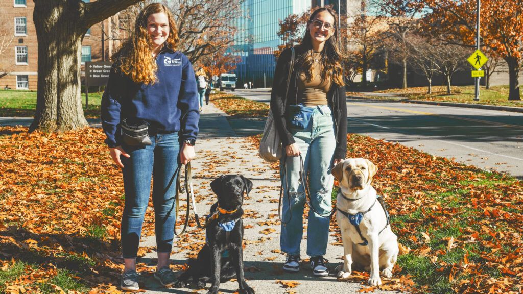 Alyssa Roorda (left) and Zoe Weissbach with their guiding eyes puppies