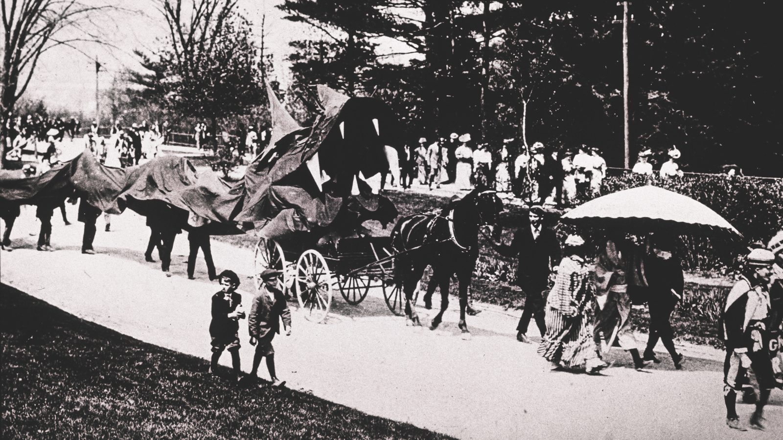 A toothy dragon, a horse and buggy, and children in knickers are shown in this view from the early 1900s.