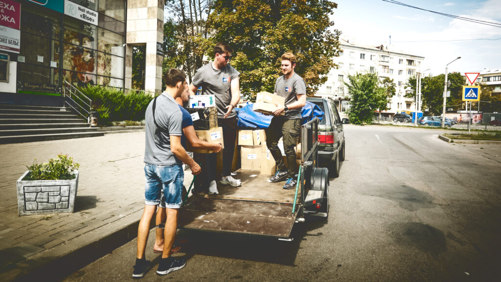 A group of men unloading supplies from a truck on a city road.