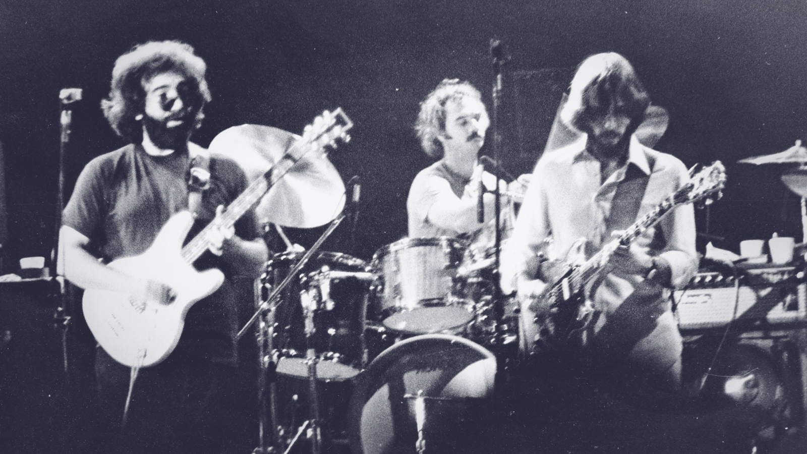 A black-and-white photograph of the Grateful Dead performing at Cornell University in 1977.