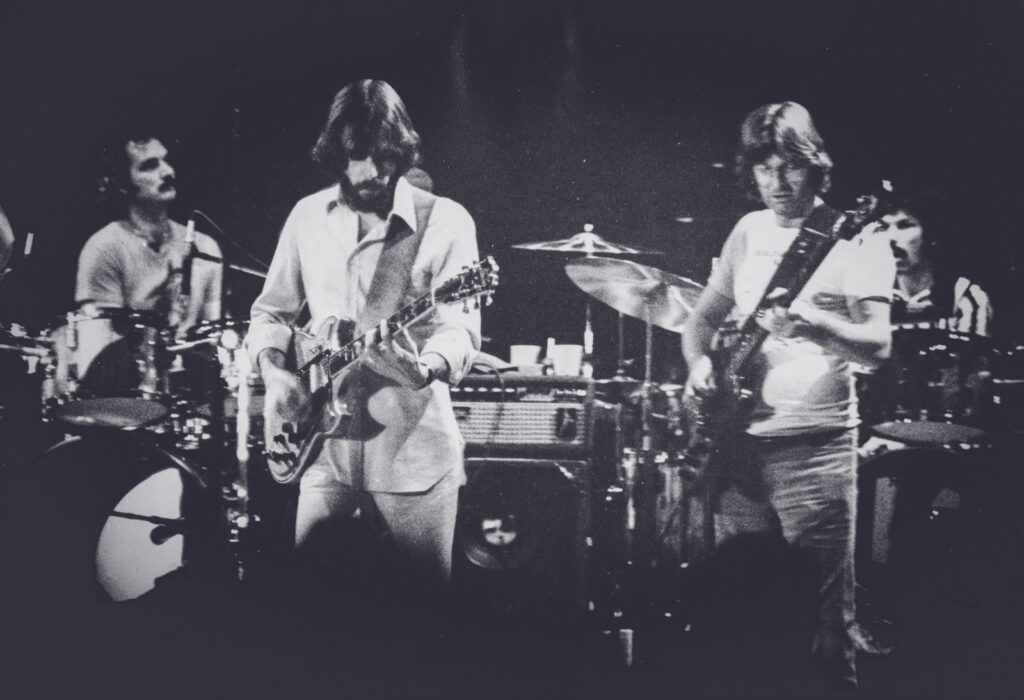 A black-and-white photo of the Grateful Dead performing at Cornell University in 1977.