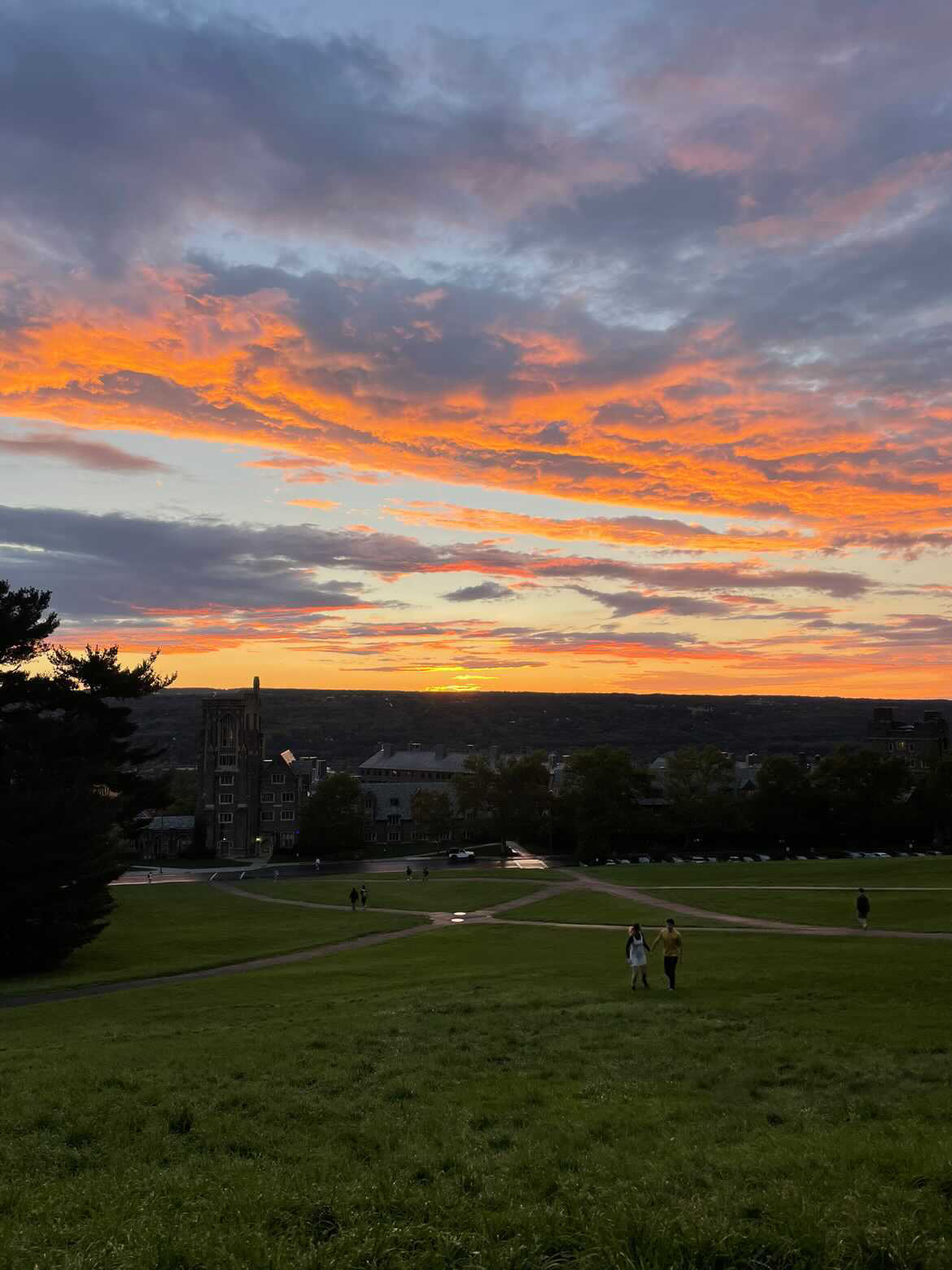 A cloudy orange-and-gray sunset over Libe Slope at Cornell University.