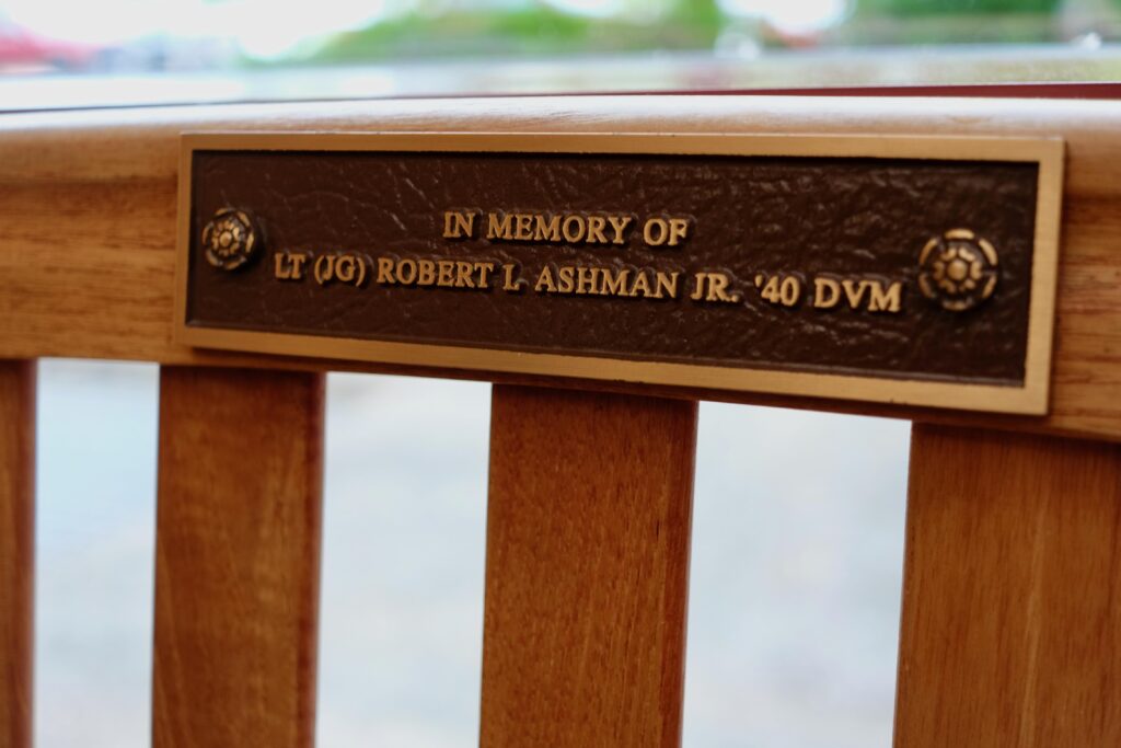 A close up of a plaque on a bench that reads: In memory of Lt (JG) Robert L. Ashman Jr. ’40 DVM