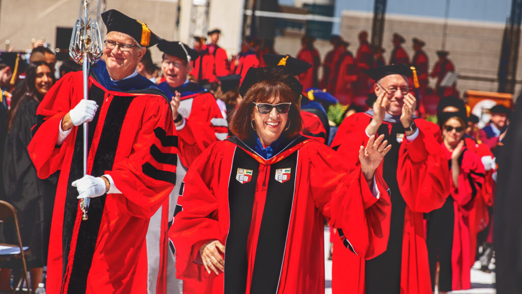 Professor Emeritus David Lee, President Martha Pollack, and others lead the academic procession out of Schoellkopf Stadium following the Commencement ceremony