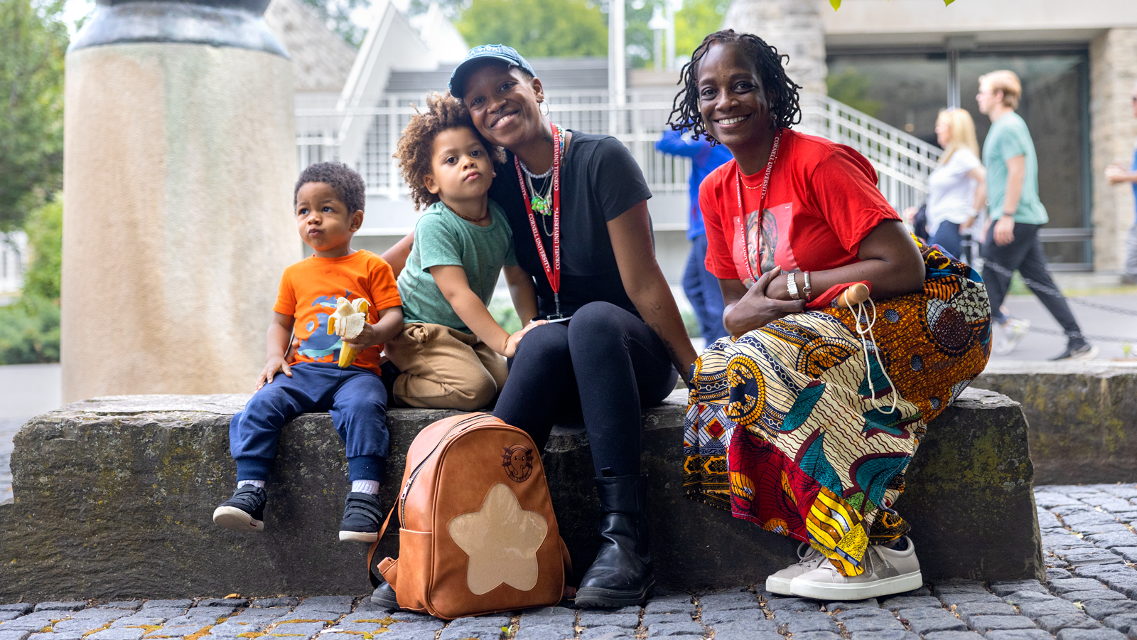 A family takes a break outside Olin Library during Reunion 2023