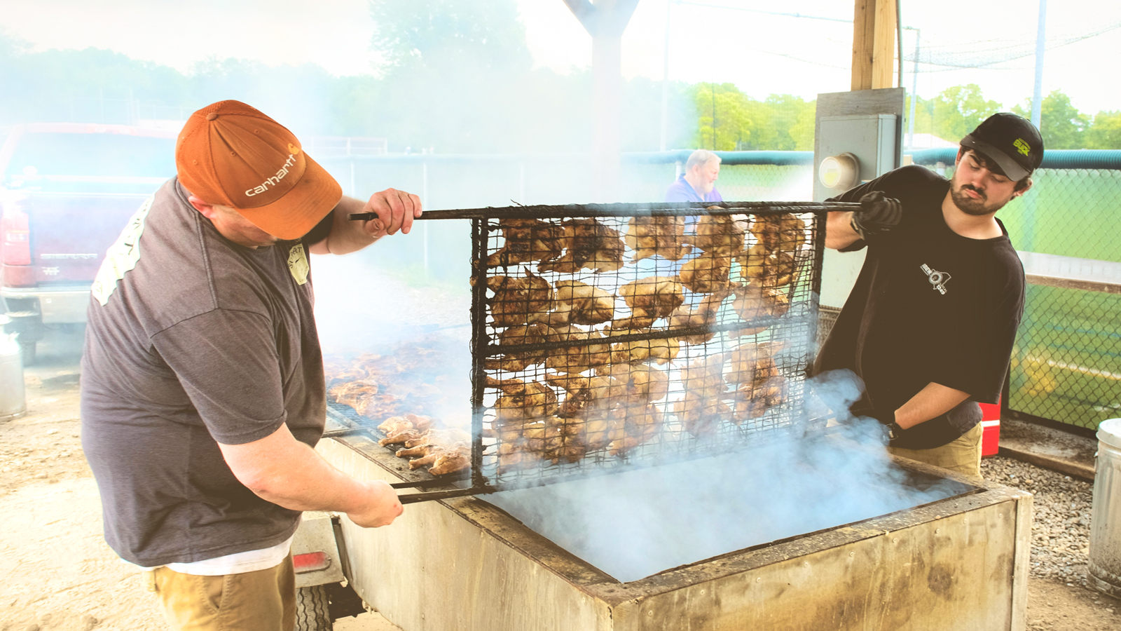 Roasters are turned during grilling at a recent barbecue featuring the Cornell Chicken recipe