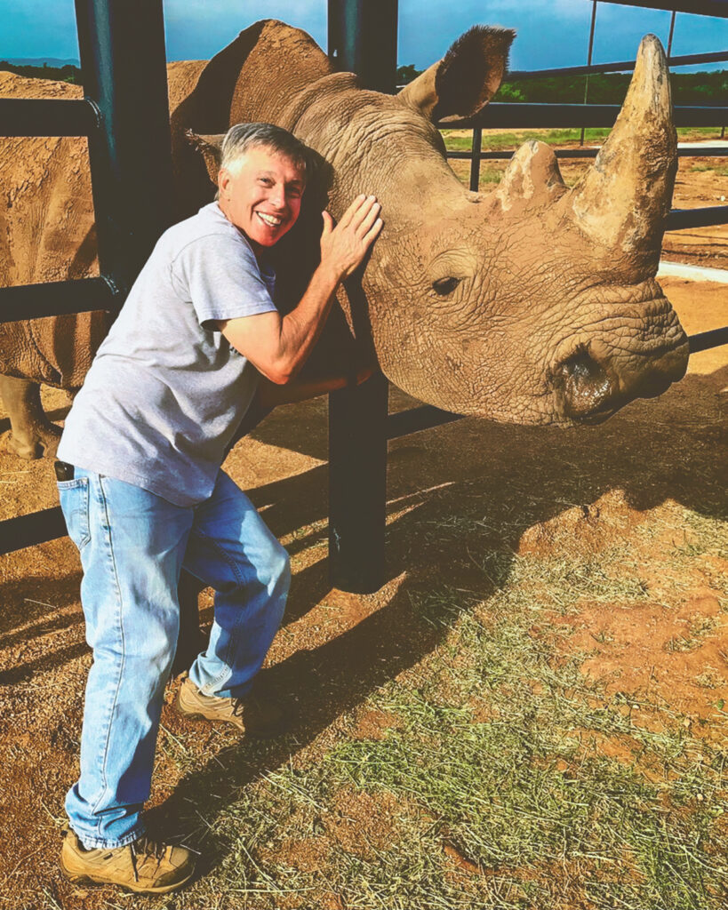 A man poses with a rhino