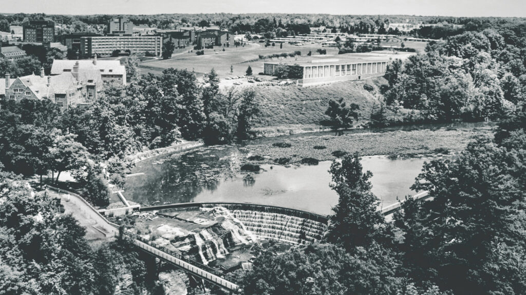 A B&W photo of a bird's eye view of the lake and campus in the 1980s
