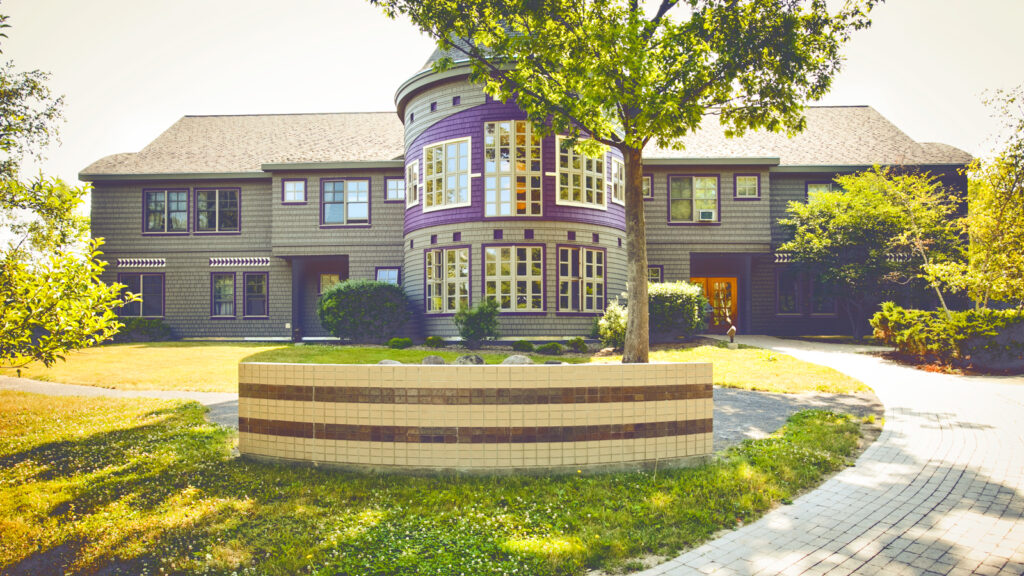 The exterior of Akwe:kon at Cornell University has vibrant purple accents and painted symbols throughout.
