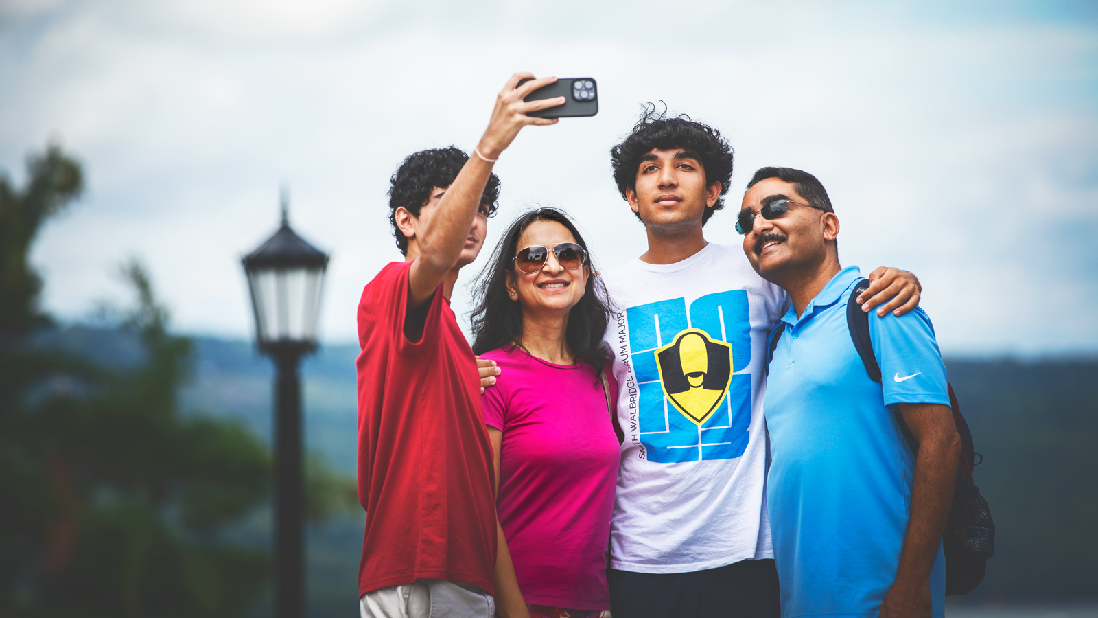 A family of four poses for a selfie.