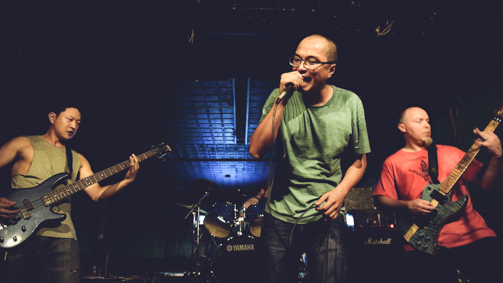 Three men performing in a punk rock group.