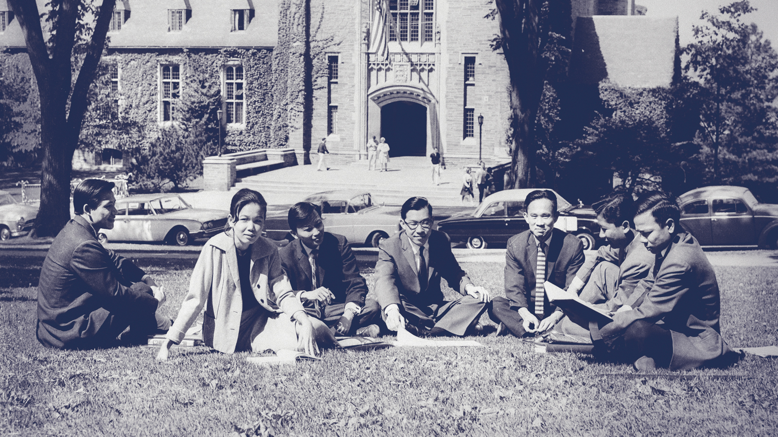 A group of Thai students sitting outside on the grass at Cornell University in the 1960s.