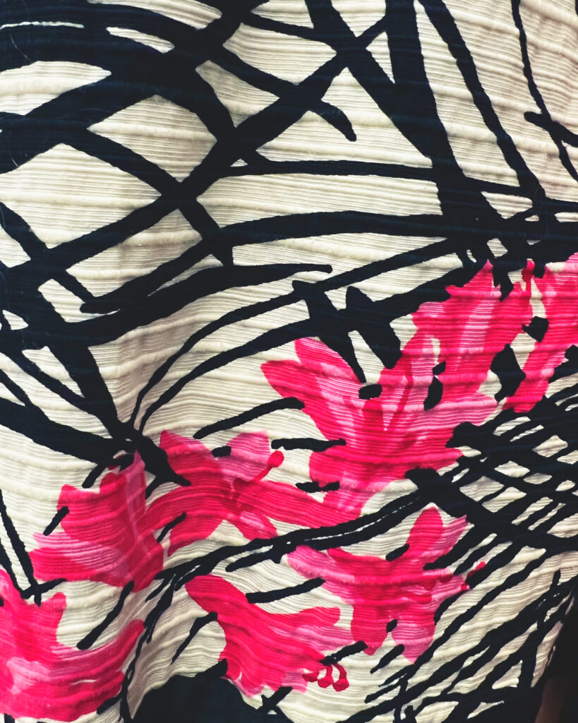 A closeup of silk material with a bright pink floral pattern