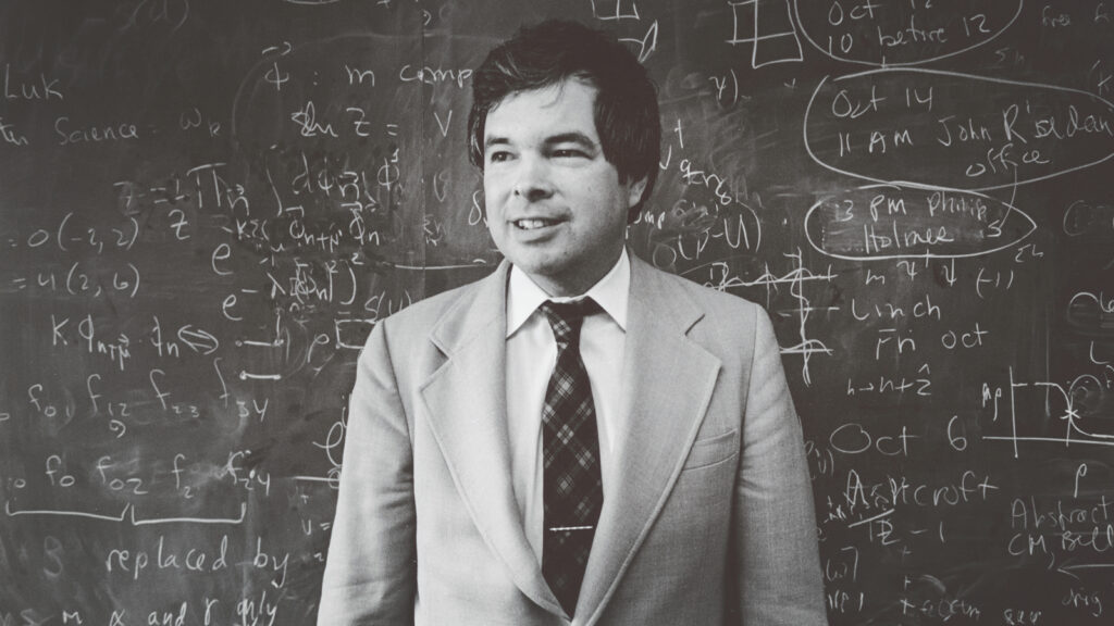 Kenneth Wilson in front of a chalkboard