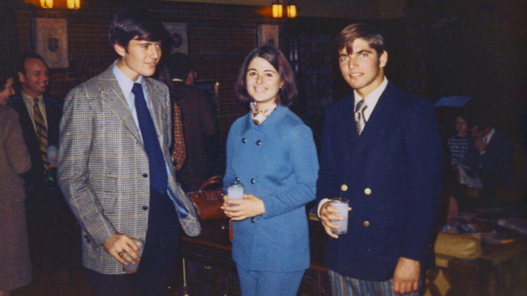 Two men and a woman at a college party in the 1970s.