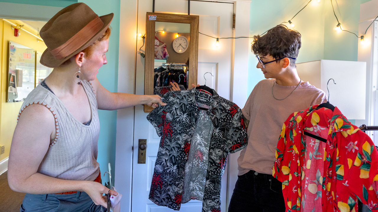 Doctoral students Alex Nik Pasqualini (right) and Morgan Irons browse shirts at the Life Transitions Closet.