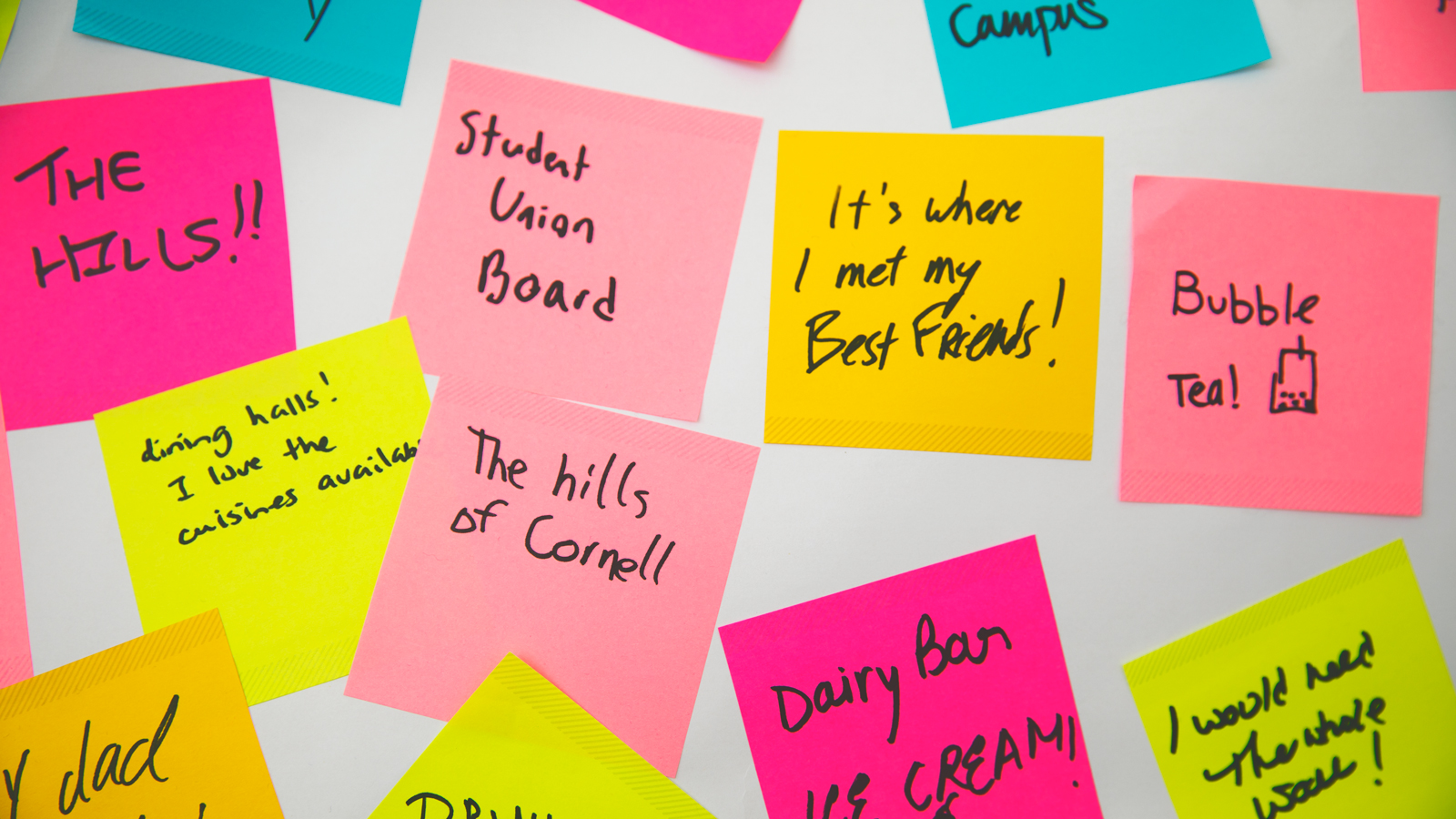 Image of multiple Post-It notes, some of which say: the hills!!; Student Union board; it's where I met my best friends!; bubble tea; dining halls! I love the cuisines available; the hills of Cornell; Dairy Bar ice cream; and I would need the whole wall!