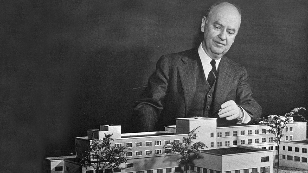 Howard Bagnall Meek, founding dean of the Nolan Hotel School, surveys a model of Statler Hall during the 1940s