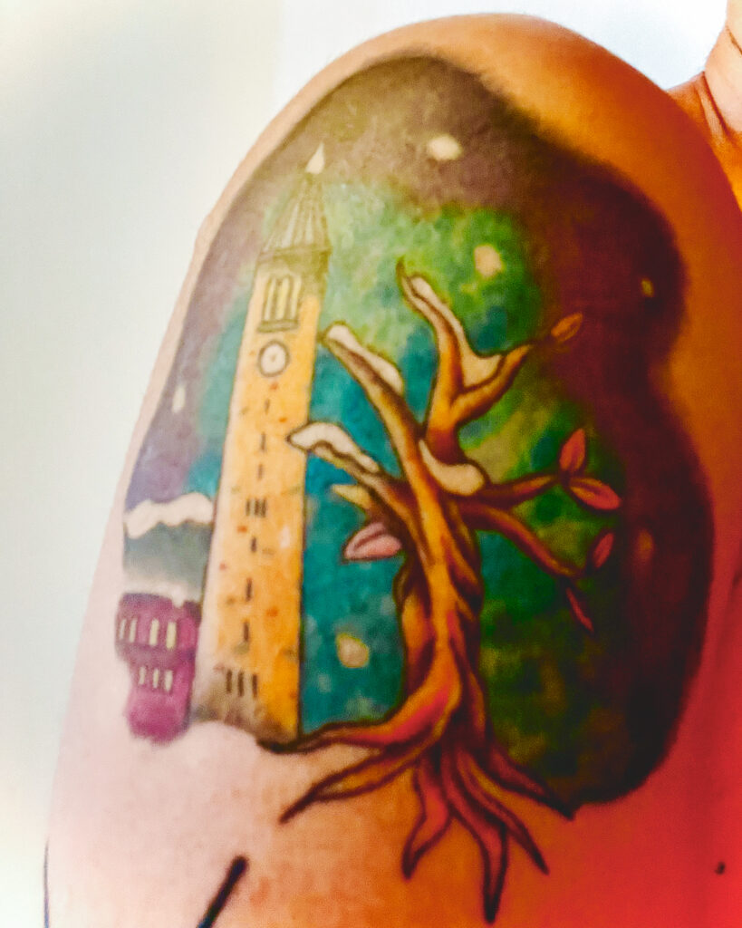 A colorful tattoo of a tree and Cornell University's McGraw Tower.
