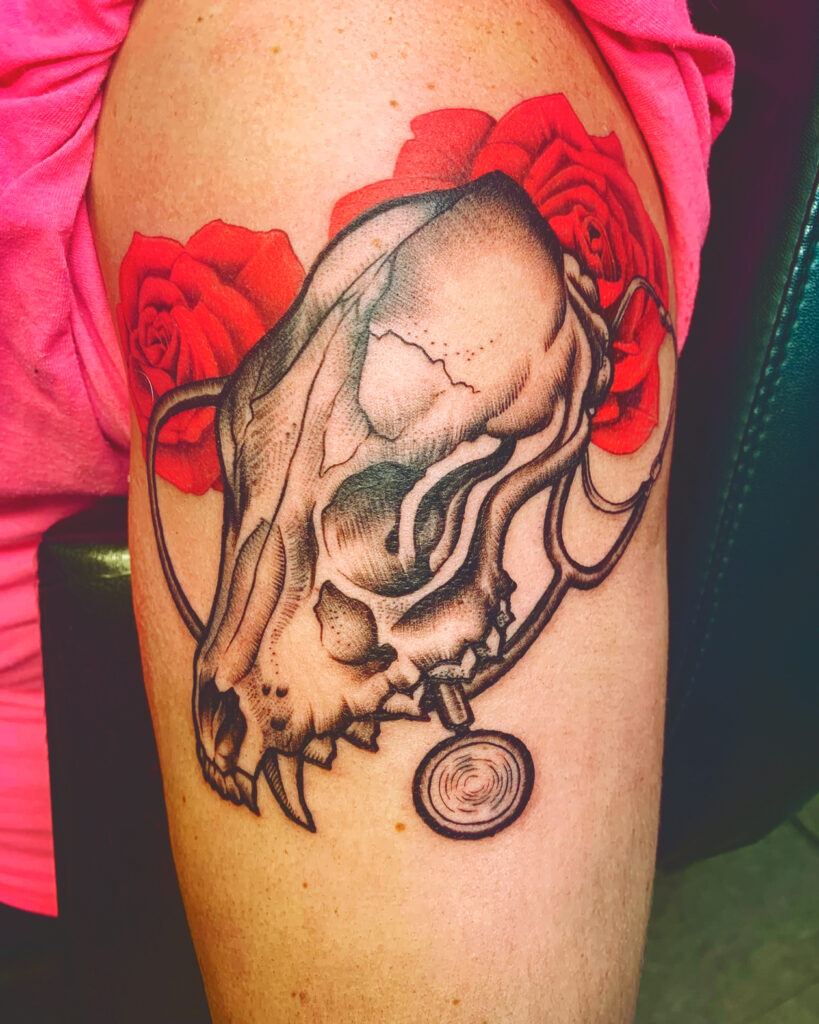 A tattoo of a canine skull with a stethoscope and red roses