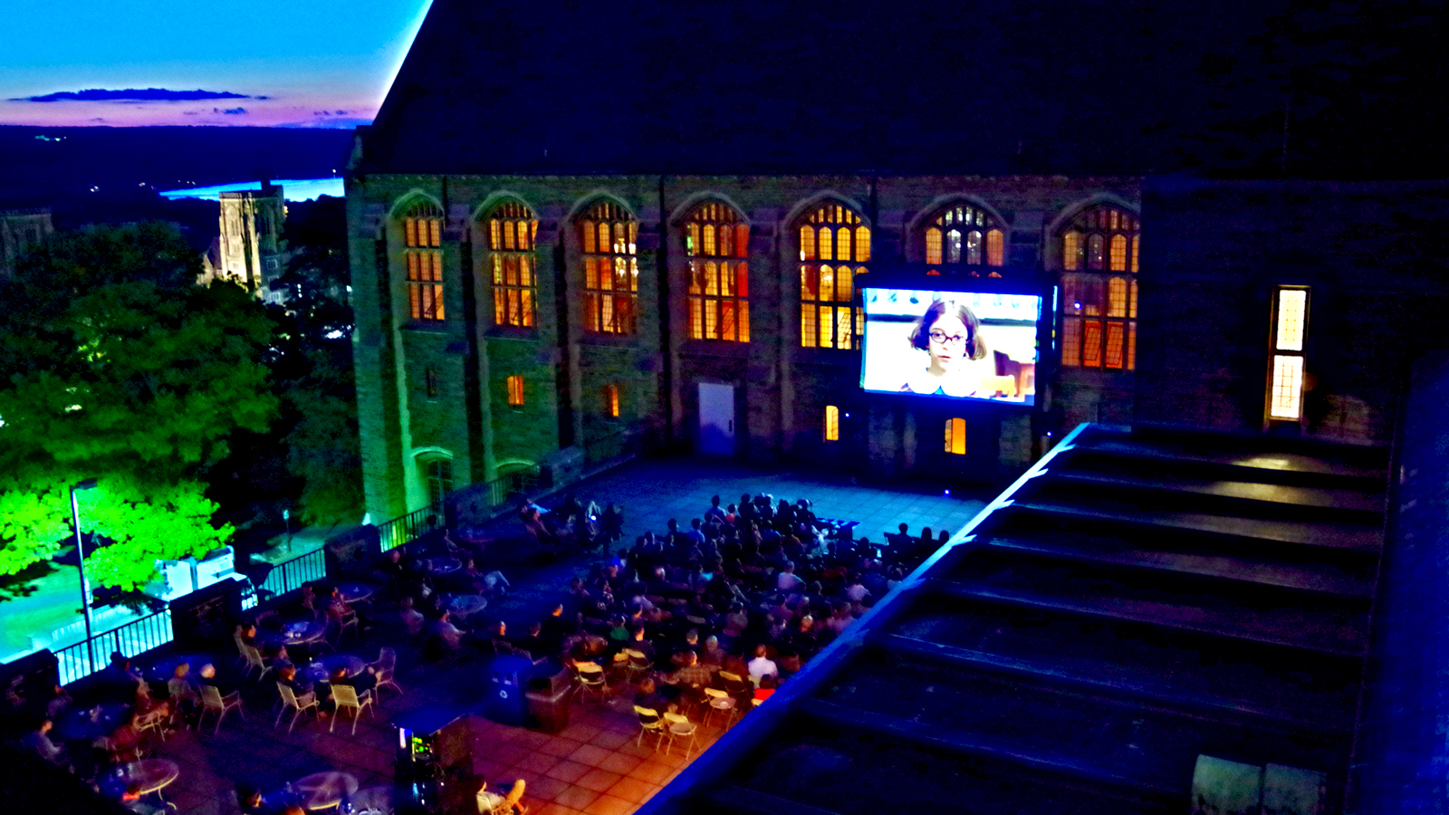 A movie being screened outside to an audience at Willard Straight Hall at Cornell University
