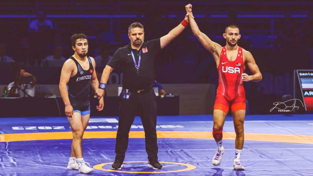 Two professional wrestlers and a referee at the World Wrestling Championships in 2023.