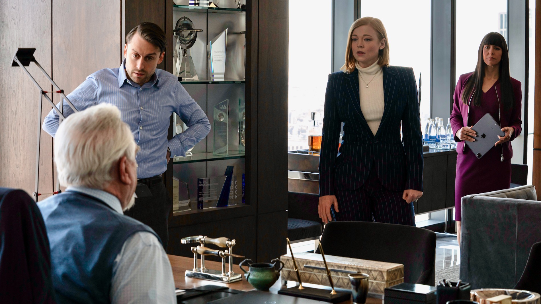A scene in an office from the TV show "Succession" with the actors Brian Cox, Kieran Culkin, Sarah Snook, Zoë Winters