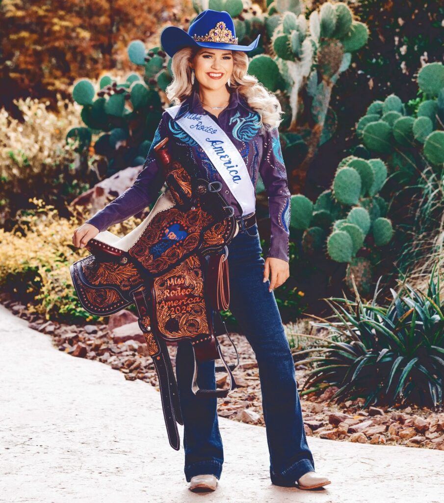 Emma Cameron in her Miss Rodeo America attire, with sash, crown, and trophy saddle