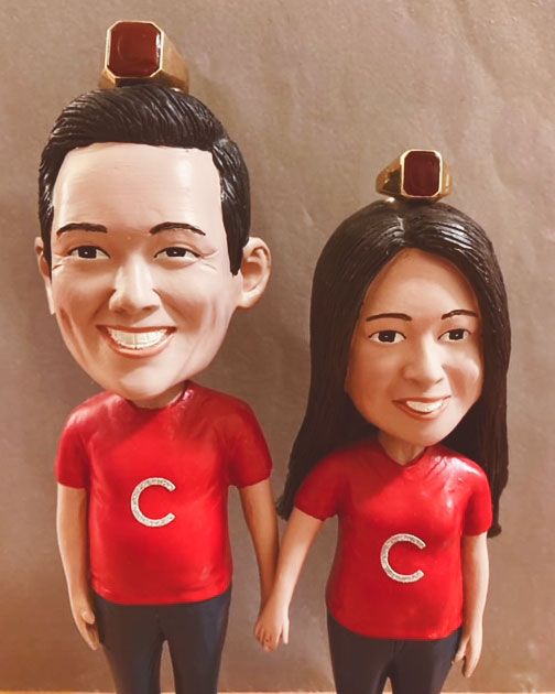 Bobblehead figures of Jae Chang ’95, BS ’96 and Sujin Lim Chang ’96 with carnelian Cornell rings atop their heads