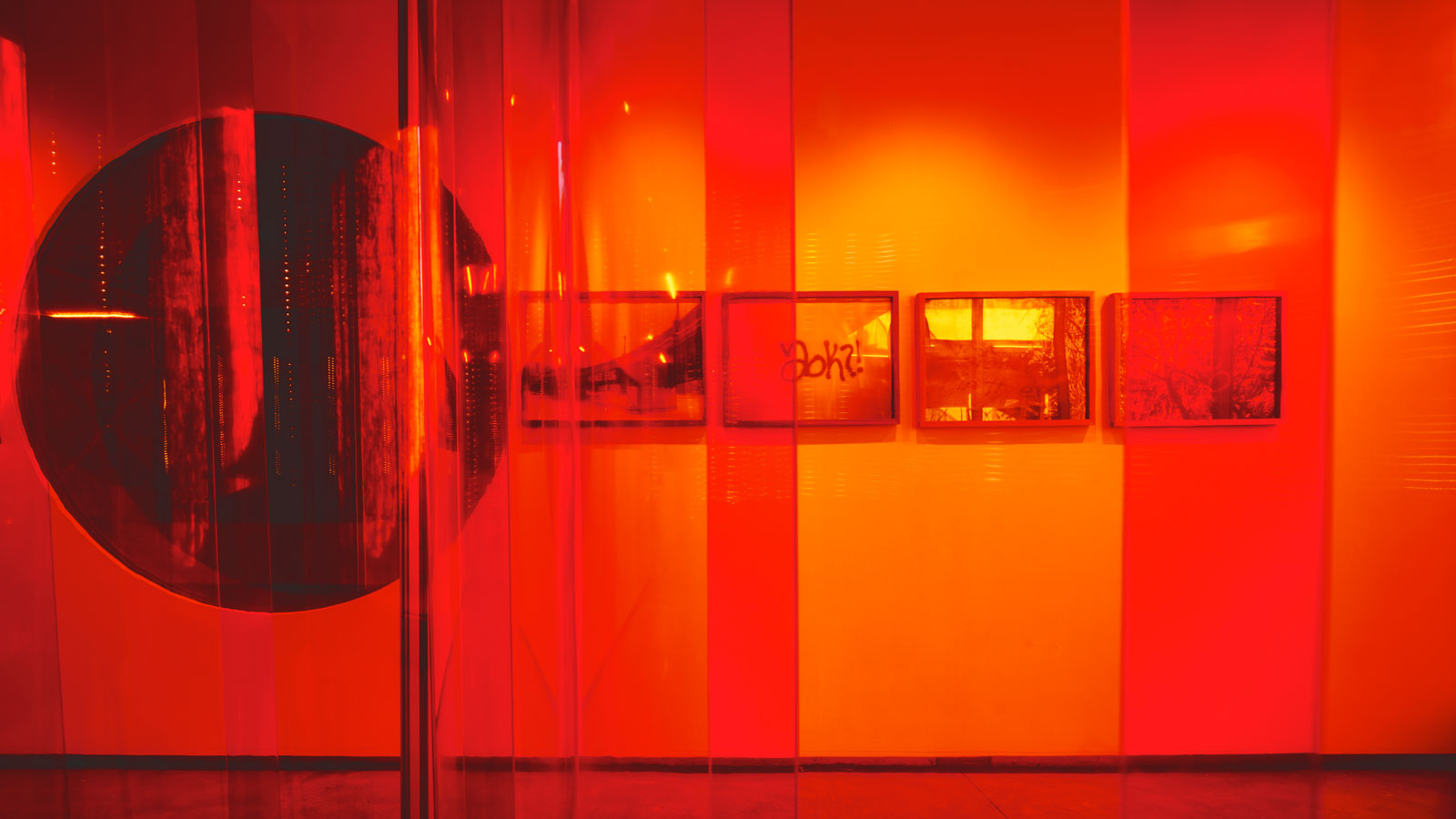 A red-tinted view of four photos titled "Bywalker" by PhD candidate Nicolau Spadoni, from inside "Echo Chamber" by visiting critics Emma Silverblatt & Ryan Whitby