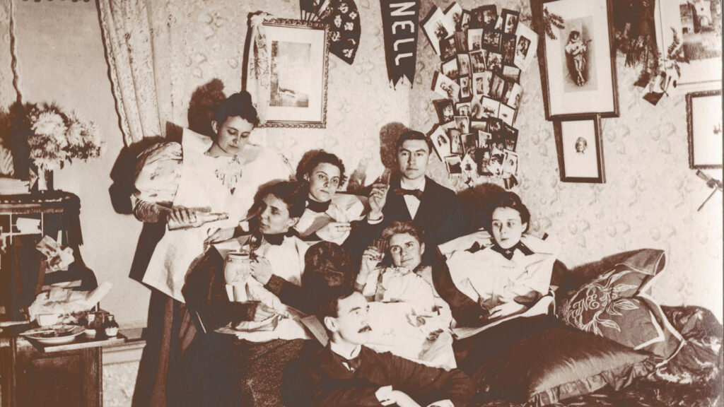 A vintage image of a group of men and women in a Sage Hall dorm room
