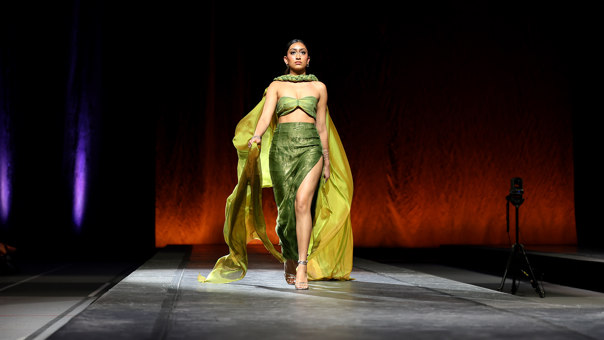 A model in green walks the runway at the 2024 40th Annual CFC Spring Fashion Show in Barton Hall.