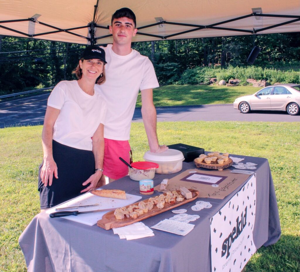 Jonah Gershon and his mom at an outdoor table offering samples of brown butter