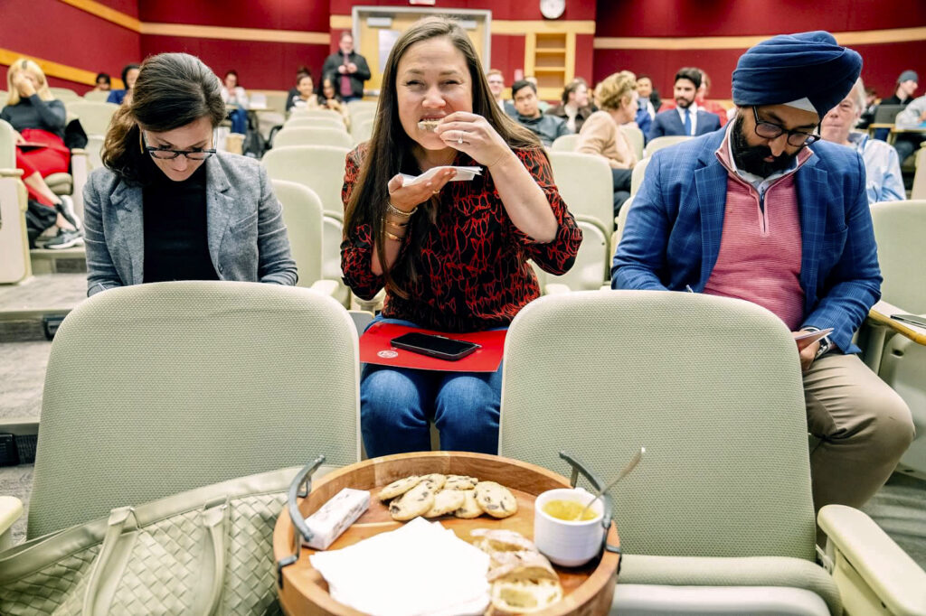Three people tasting and judging brown butter in a lecture hall