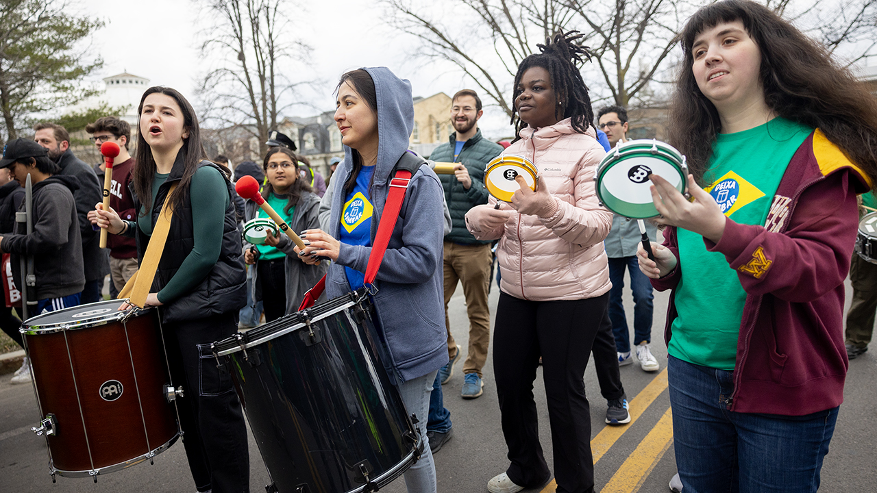 Parade participants make use of drums and tambourines